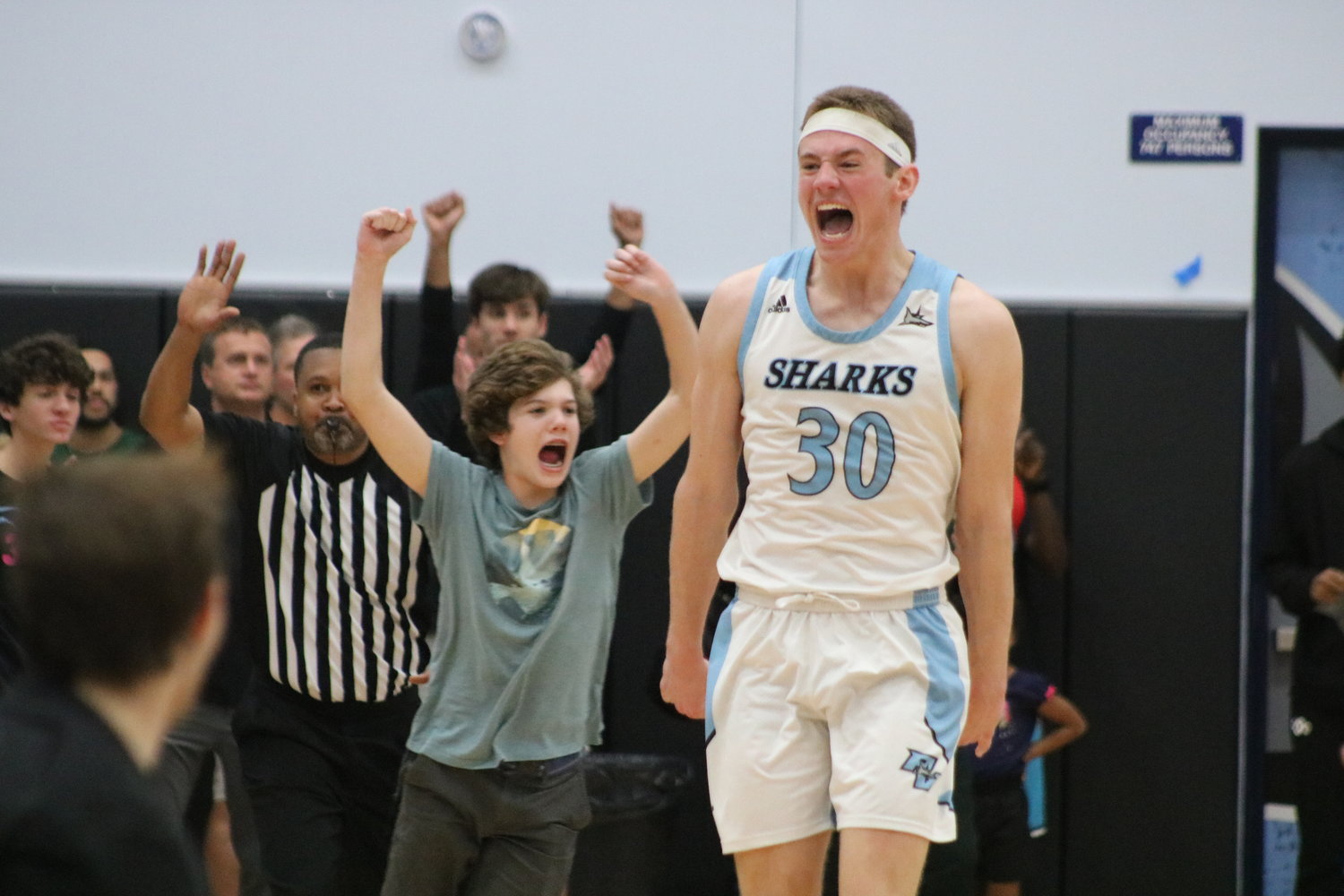 Ross Candelino shows his excitement as fans run onto the court to celebrate the school’s first boys basketball final four appearance.